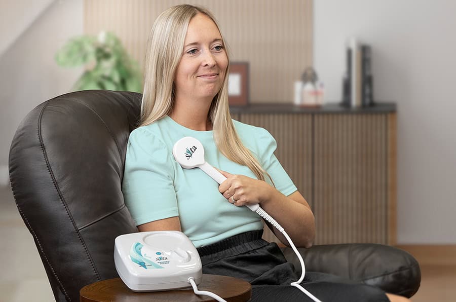 Woman using the SOTA Magnetic Pulser in a chair