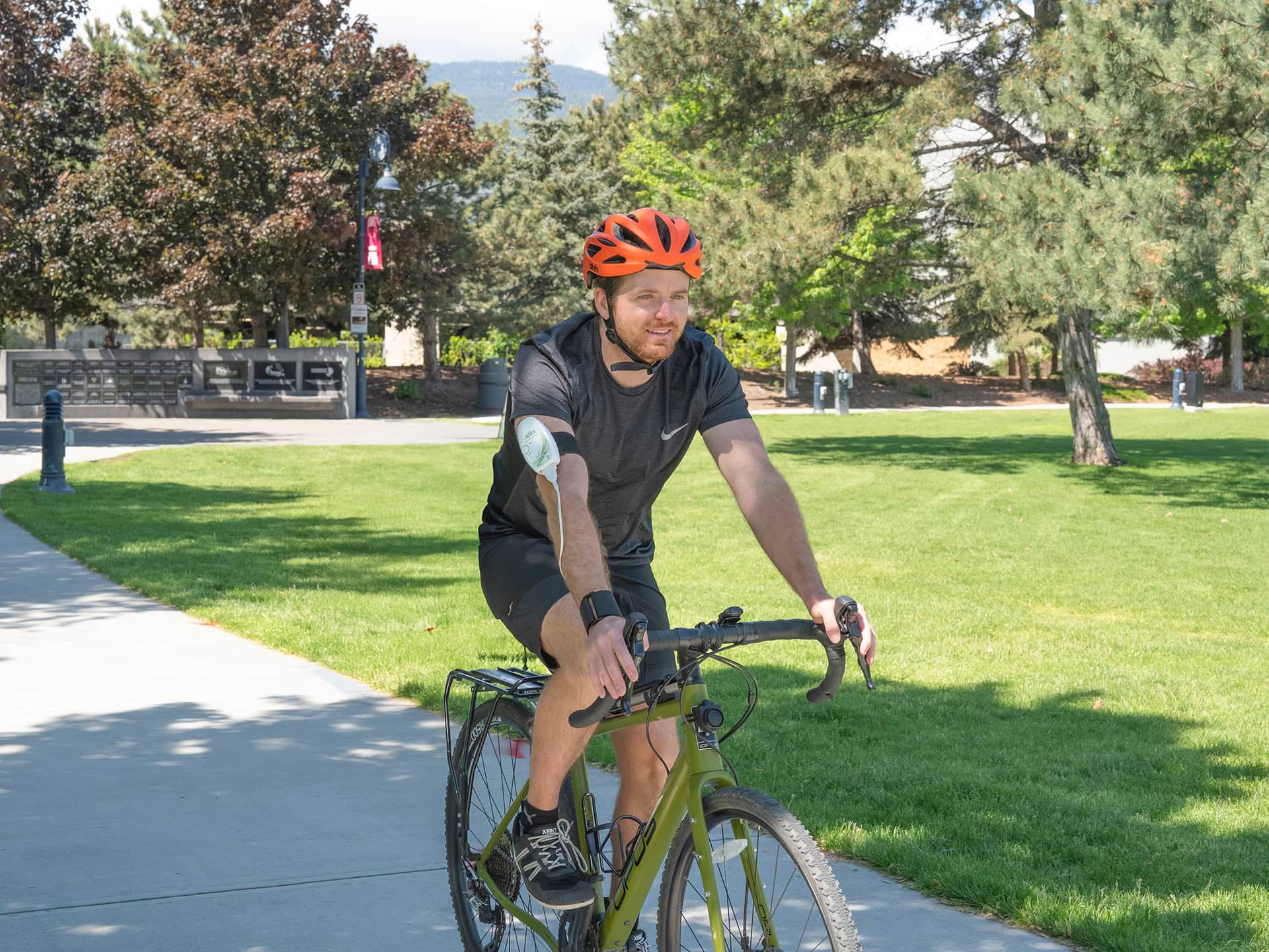 A person cycling outdoors while wearing the unit